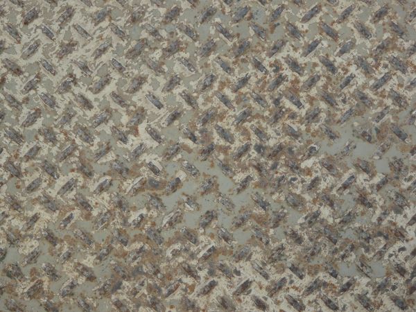 Old metal tread texture with repeating pattern and very worn surface.